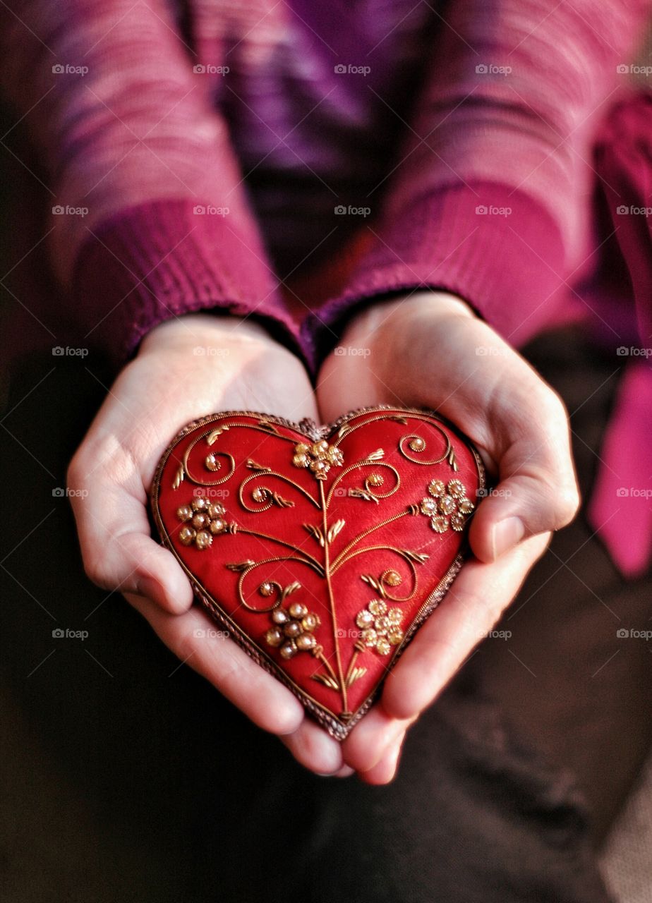 Red heart in woman hands. Woman holding heart-shaped decoration