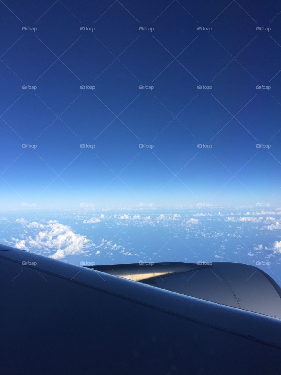 View of the Atlantic Ocean from a plane that shows the incredible blue of the sky and the shining clouds.