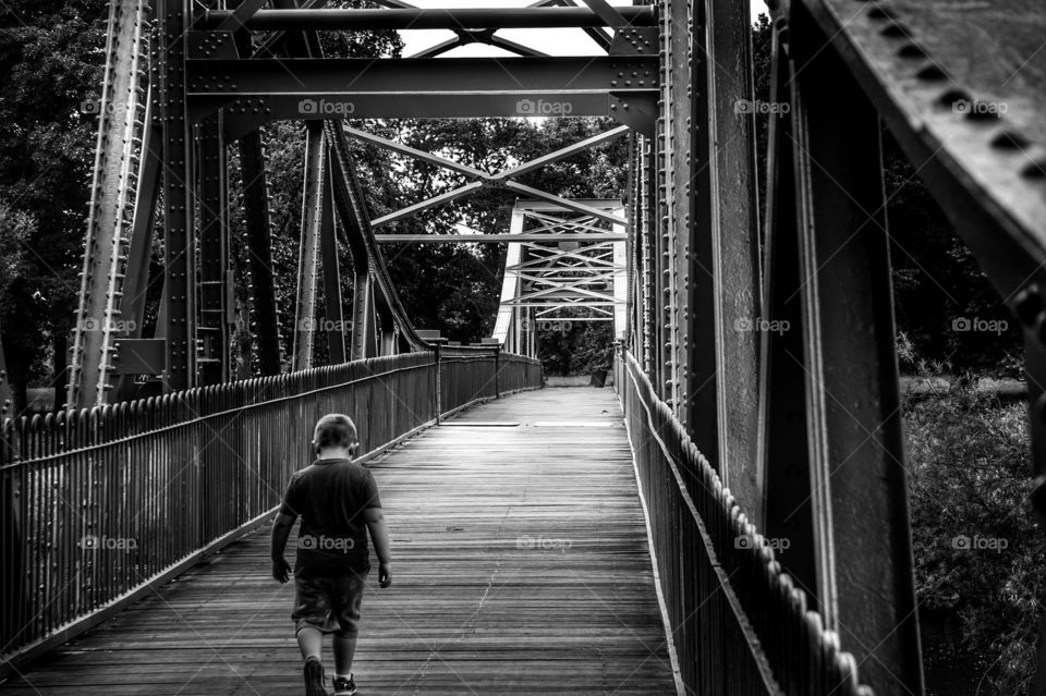 boy walking across a Bridge