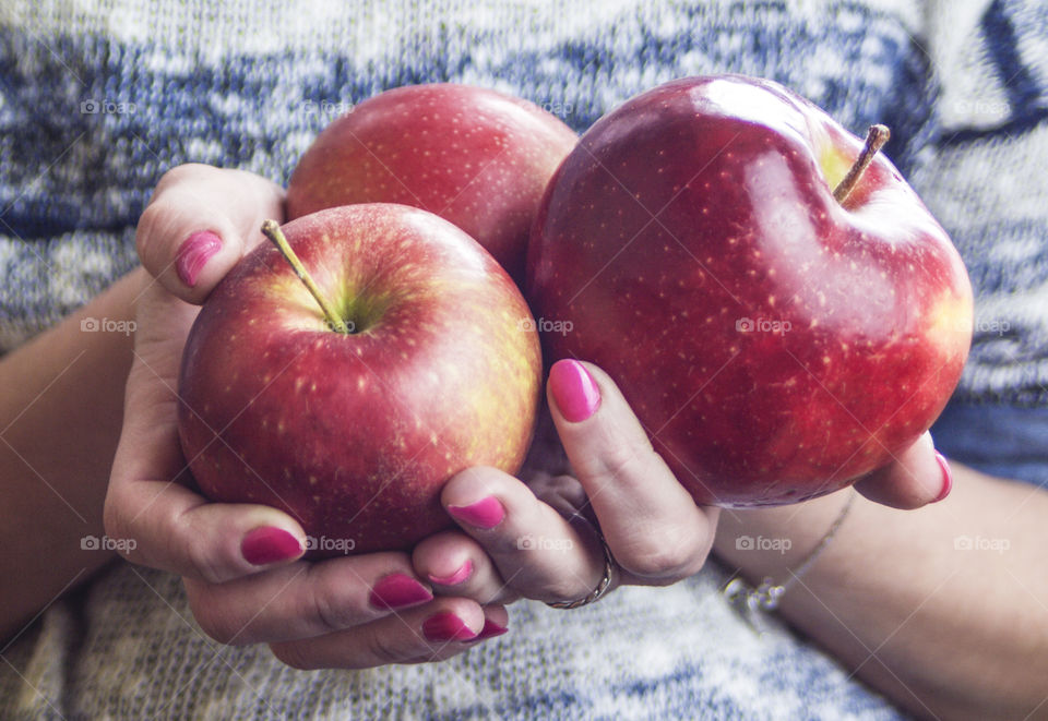 The girl is holding an apple