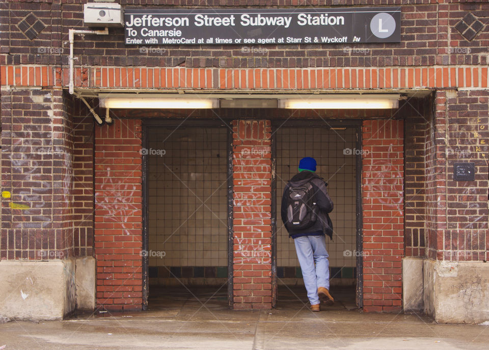 A man is running through an entrance door to an underground  New York Subway train.in Bushwick, Brooklyn, NYC