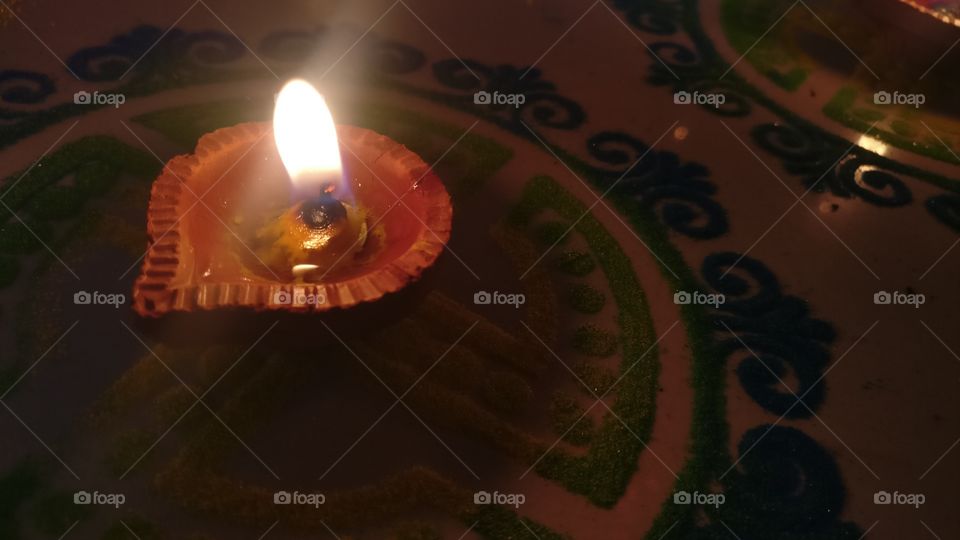 closeup shot of Lit dia lamp in center of colorful designer Rangoli deepawali Diwali celebration Rangoli indian festival