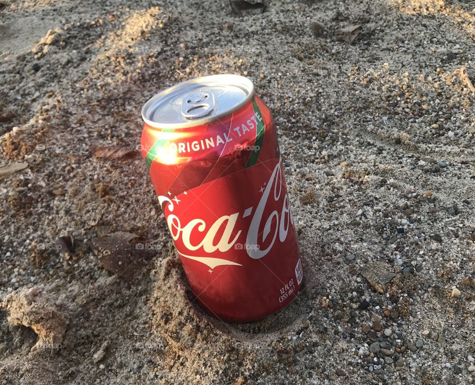 Coca Cola can in the sand 