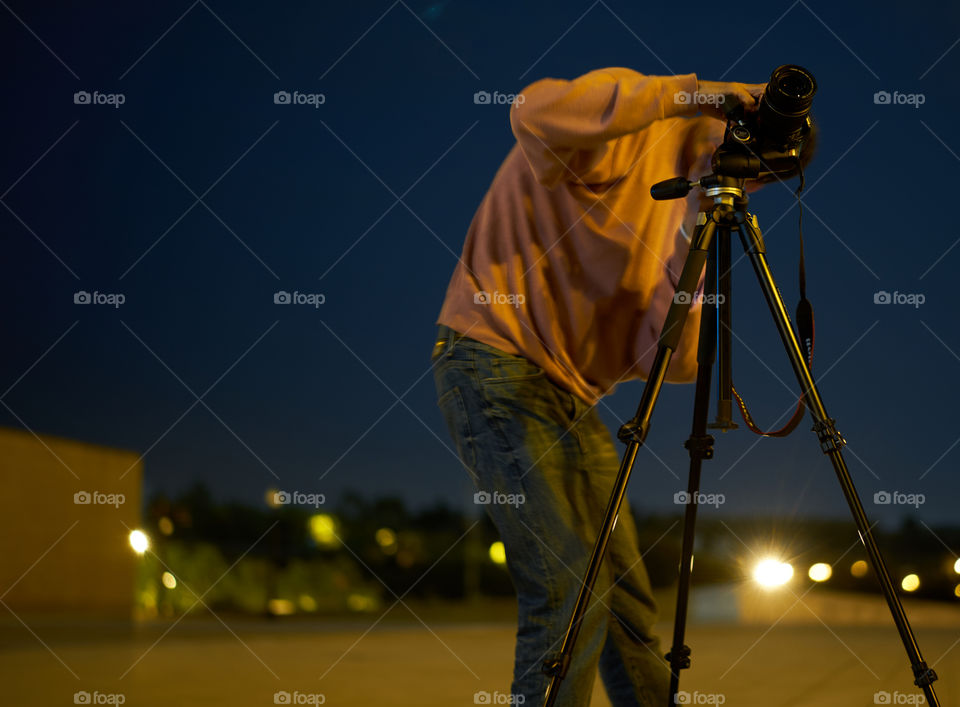 Man taking photograph with camera at night