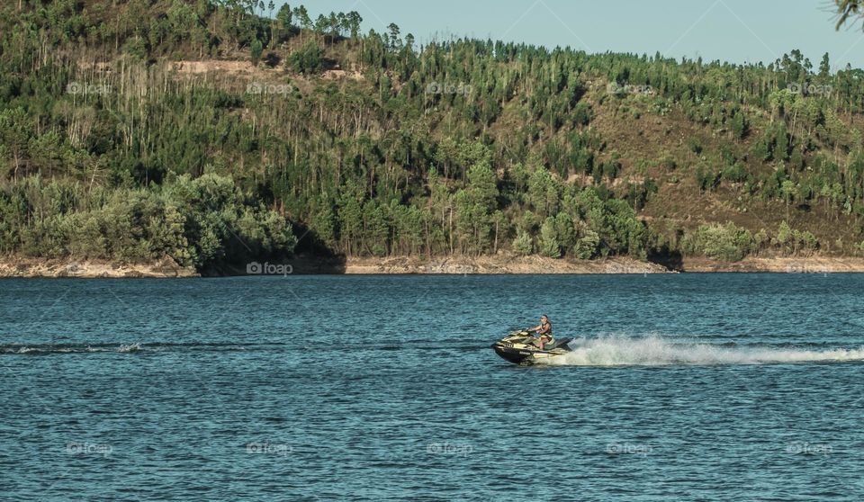 A man enjoys jet skiing along the Rio Zêzere 