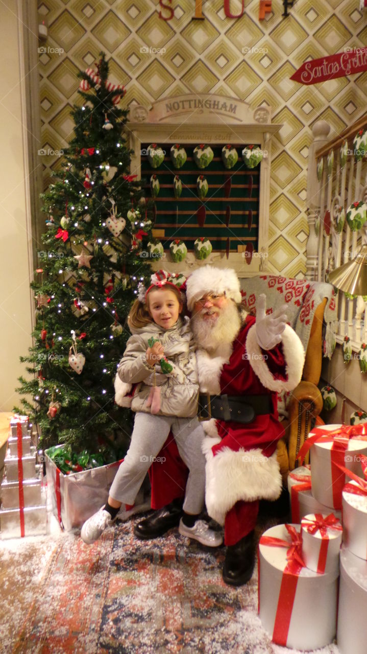 sitting on father Christmas's lap 

santa with a natural beard.