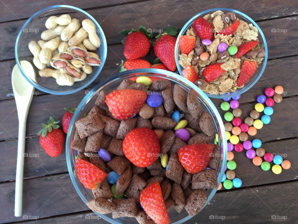 Bowls with flakes,strawberries,peanuts and colorated candy