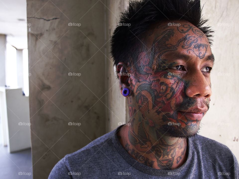 portrait of a man with facial tattoo