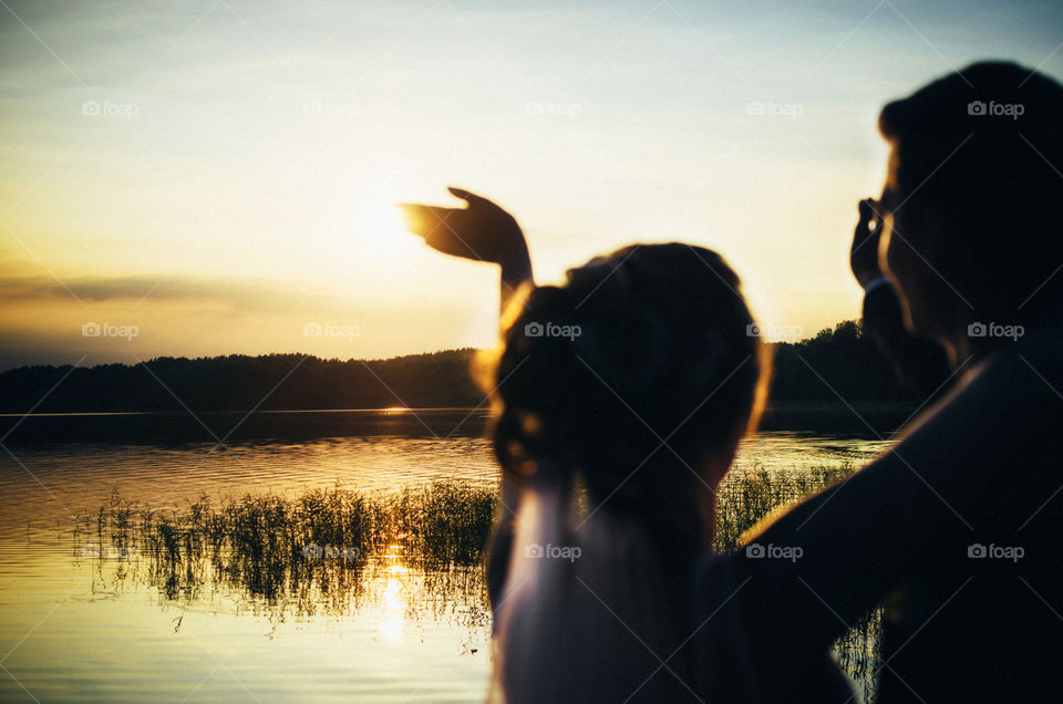 The bride welcomes the sun. Wedding concept at sunset