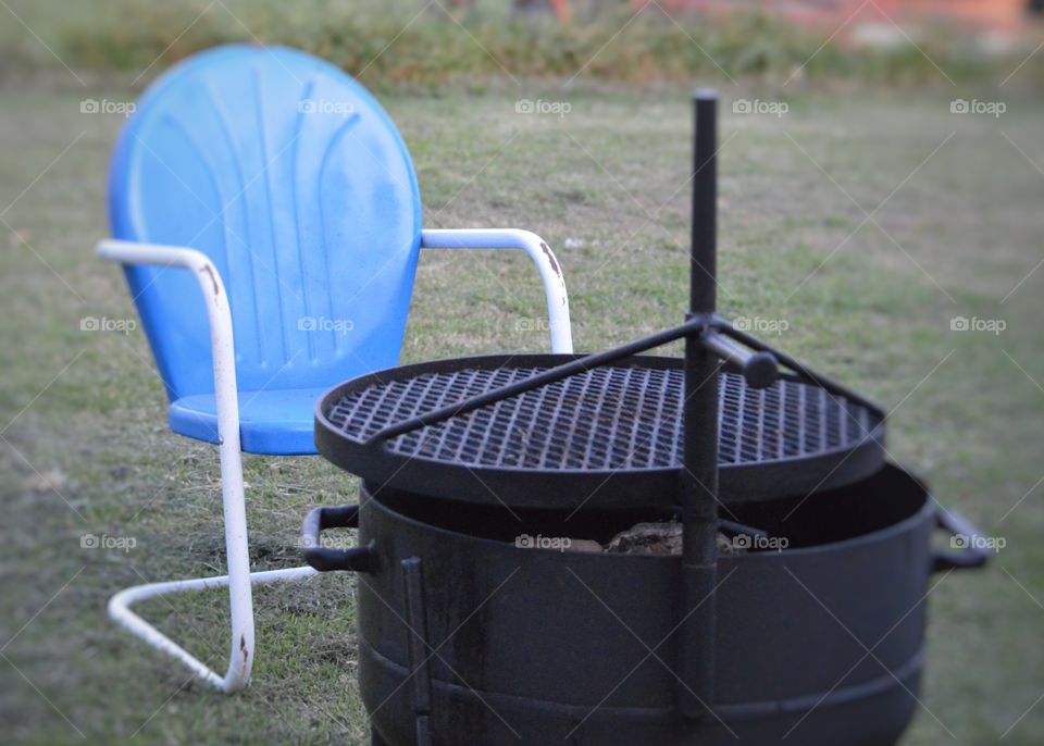 Barbecue grill with blue empty chair
