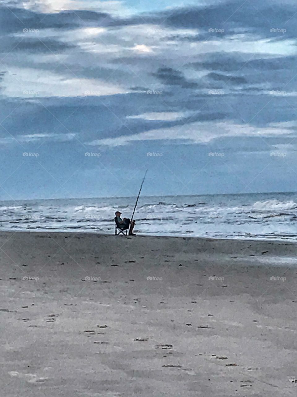 Lone man evening fishing at the beach