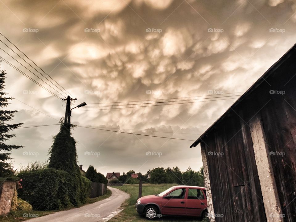weird clouds and a red car