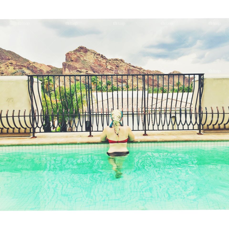 Tranquility . Girl in pool looking at mountain 
