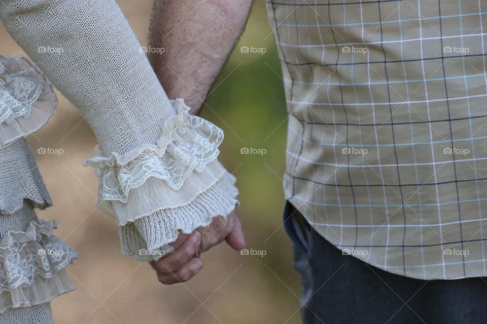 Rear view of couple holding hands