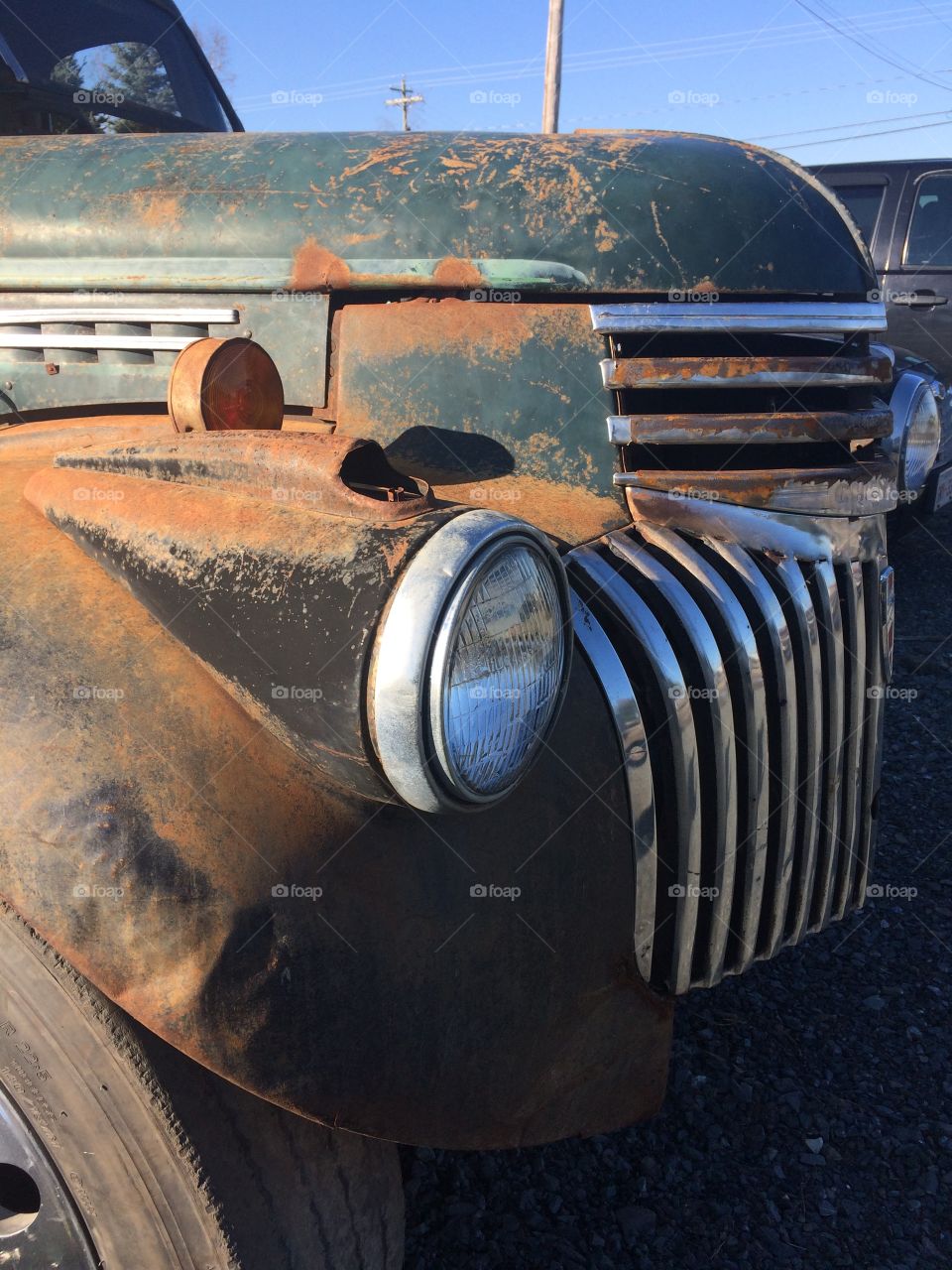 Old rusty grill and headlight of a truck