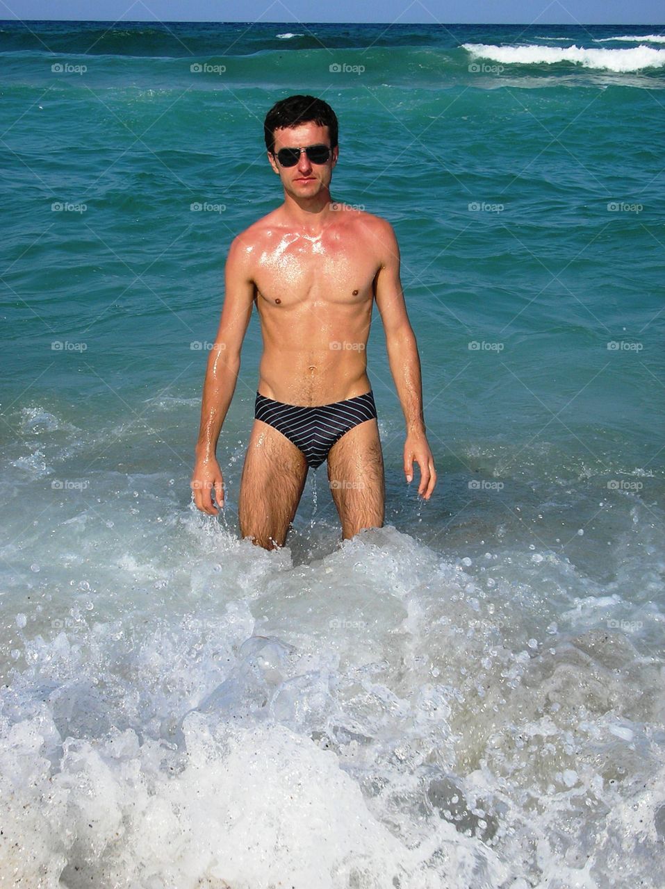 Young sporty man in the sea with waves