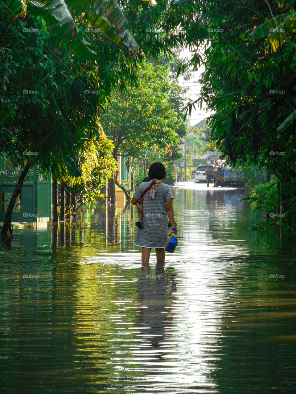 Woman with a baby walking in flood