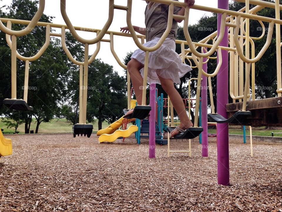 Step it up. Girl playing on a playground at the park