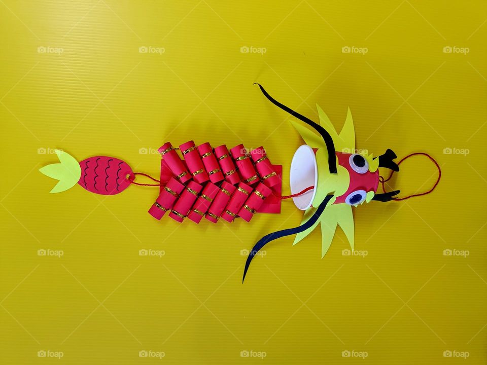 A Handmade Chinese Dragon Hanging Decoration with yellow background.Center composition.