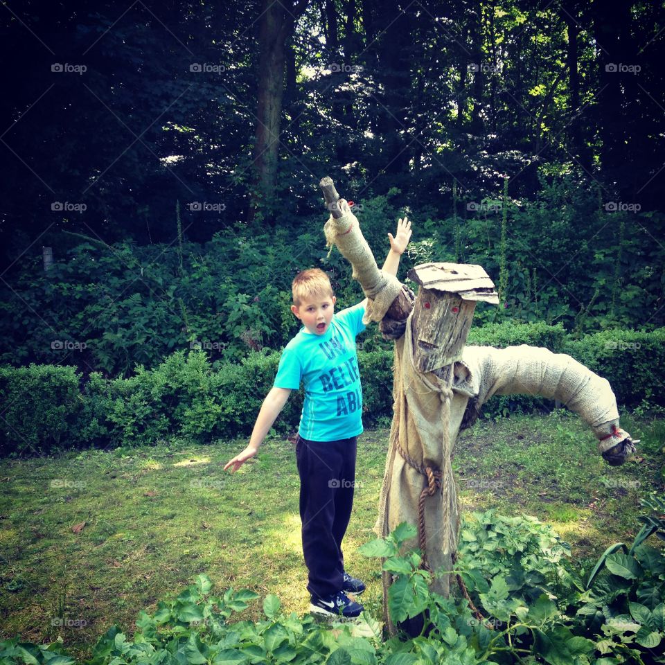 Fun at Rufford Old Hall . My son having fun in the veg patch with the scarecrow 