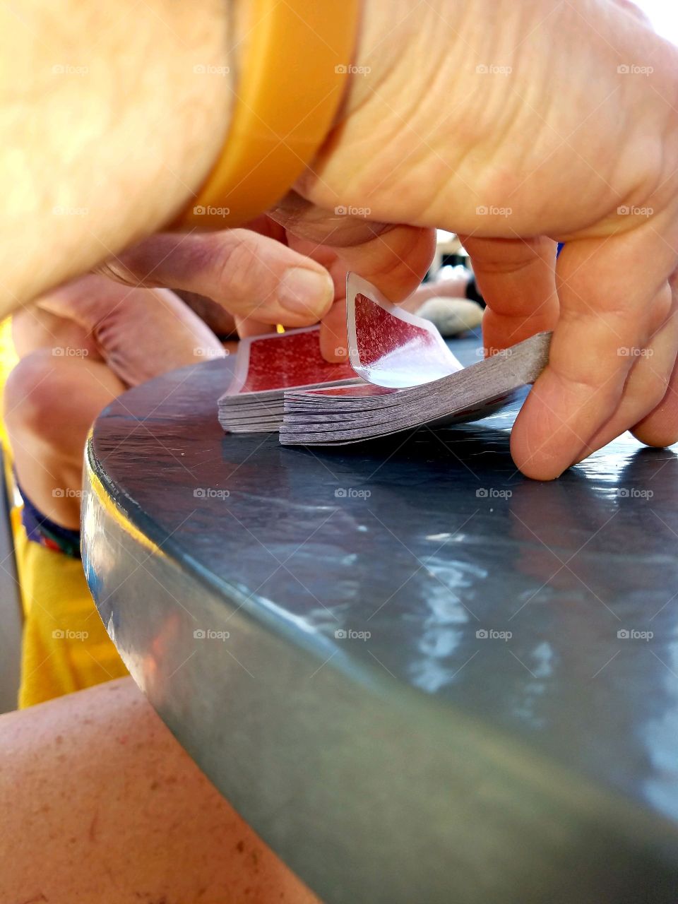 Closeup of a mans hands shuffling a deck of playing cards. Two to four people are needed to play Cribbage♠️♥️♣️♦️