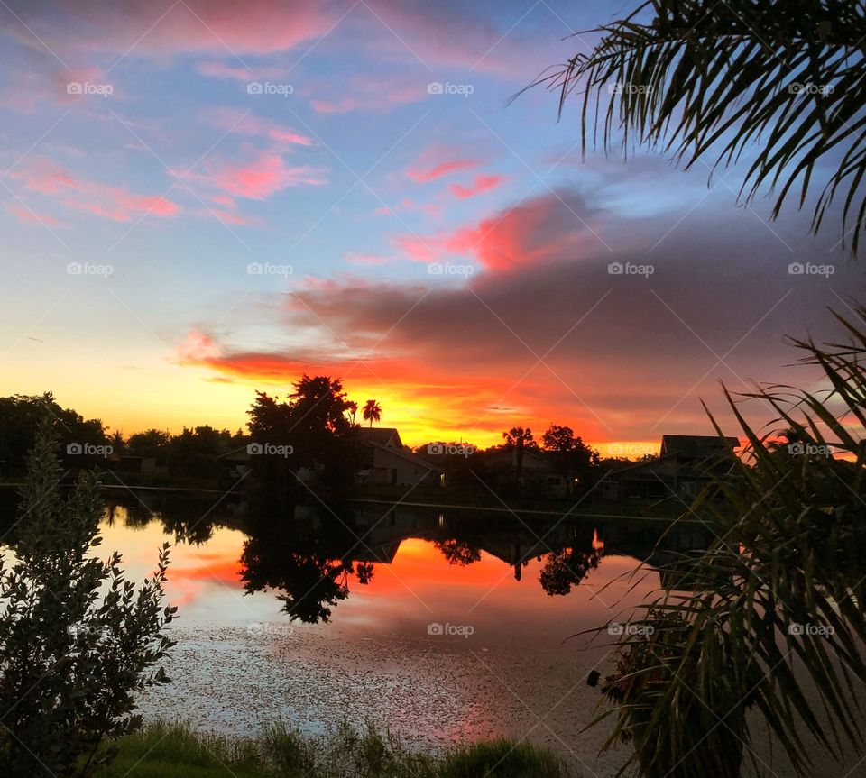 Dawn breaks  over a lake in brilliant colors. 