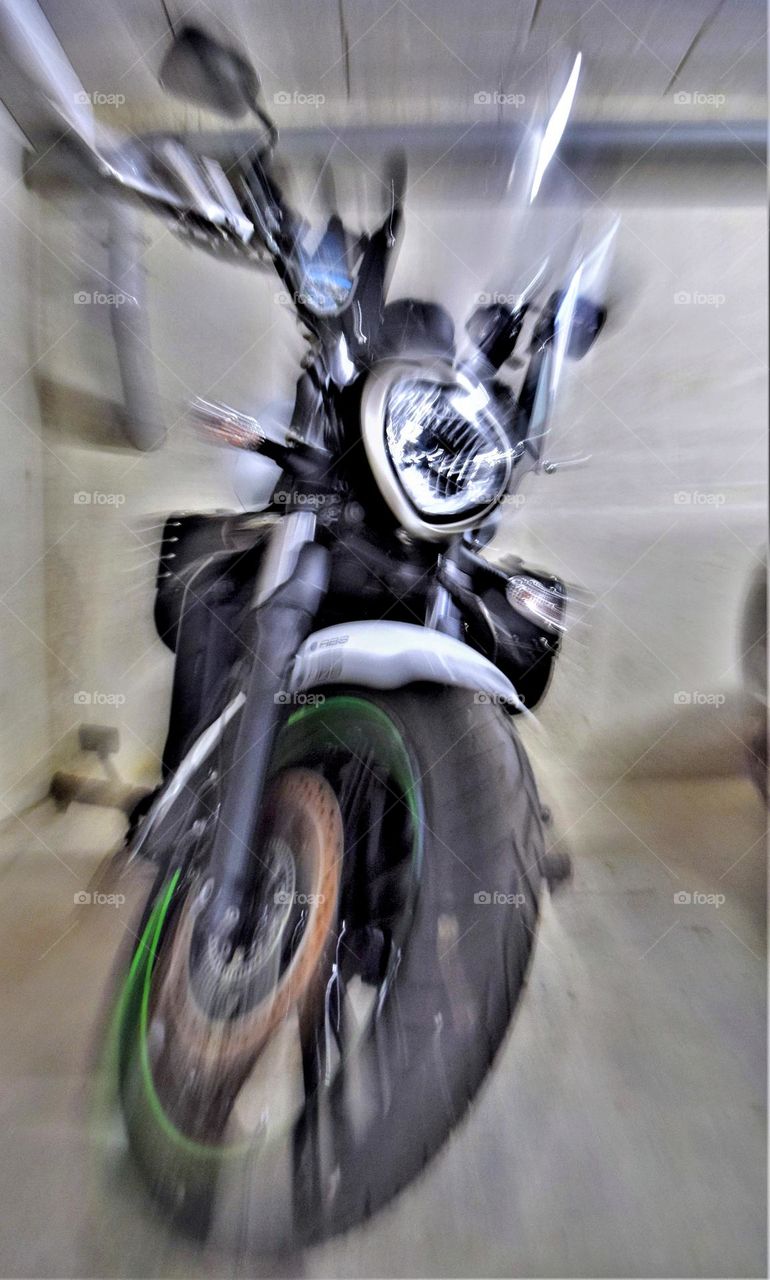 cool motorbike parked in a garage looking like it' s moving fast because of the zoom burst technique