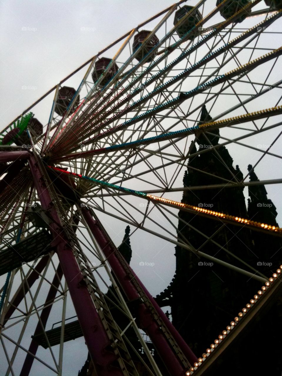 Ferris wheel on Princes Street, Edinburgh at Christmas time silhouetted against a darkening sky