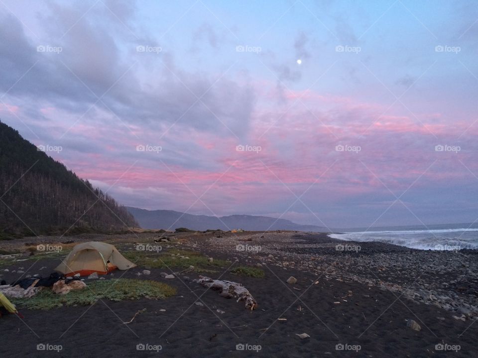 Moonbeams and a tent with pink skies and mountains and ocean on the lost coast trail in Northern California 