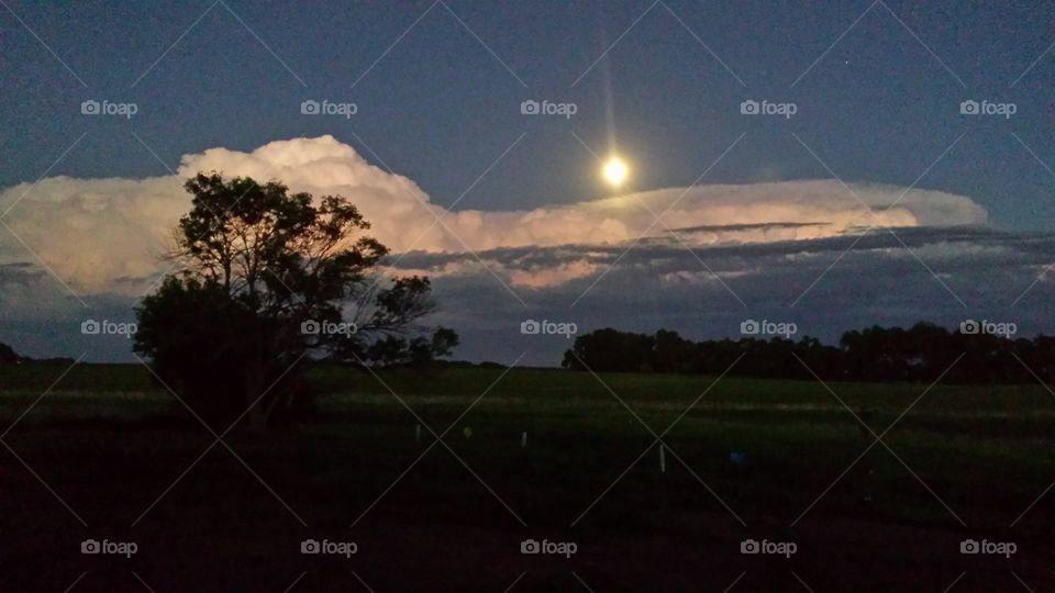 moon over a distant storm