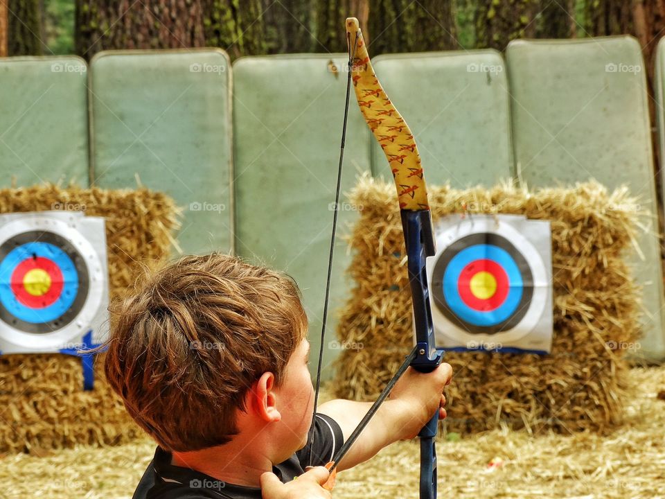Archery Range. Boy Shooting A Bow And Arrow