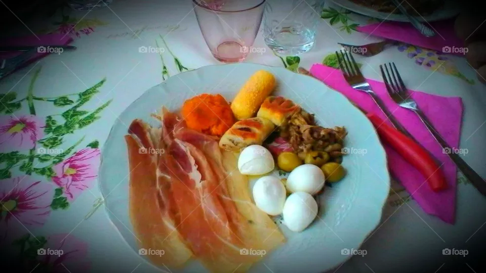 italian mixed appetizers with raw ham,  cherries of mozzarella cheese, olives and fried food stuffed with potatoes and vegetagles