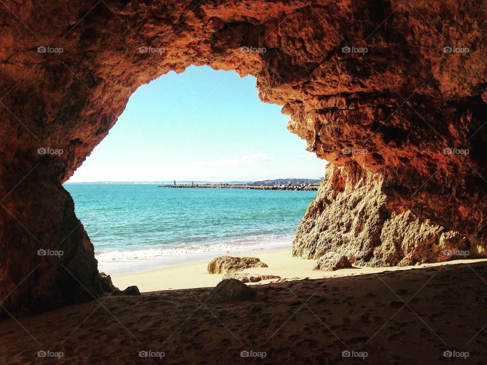 a cave on the beach opening to the sea