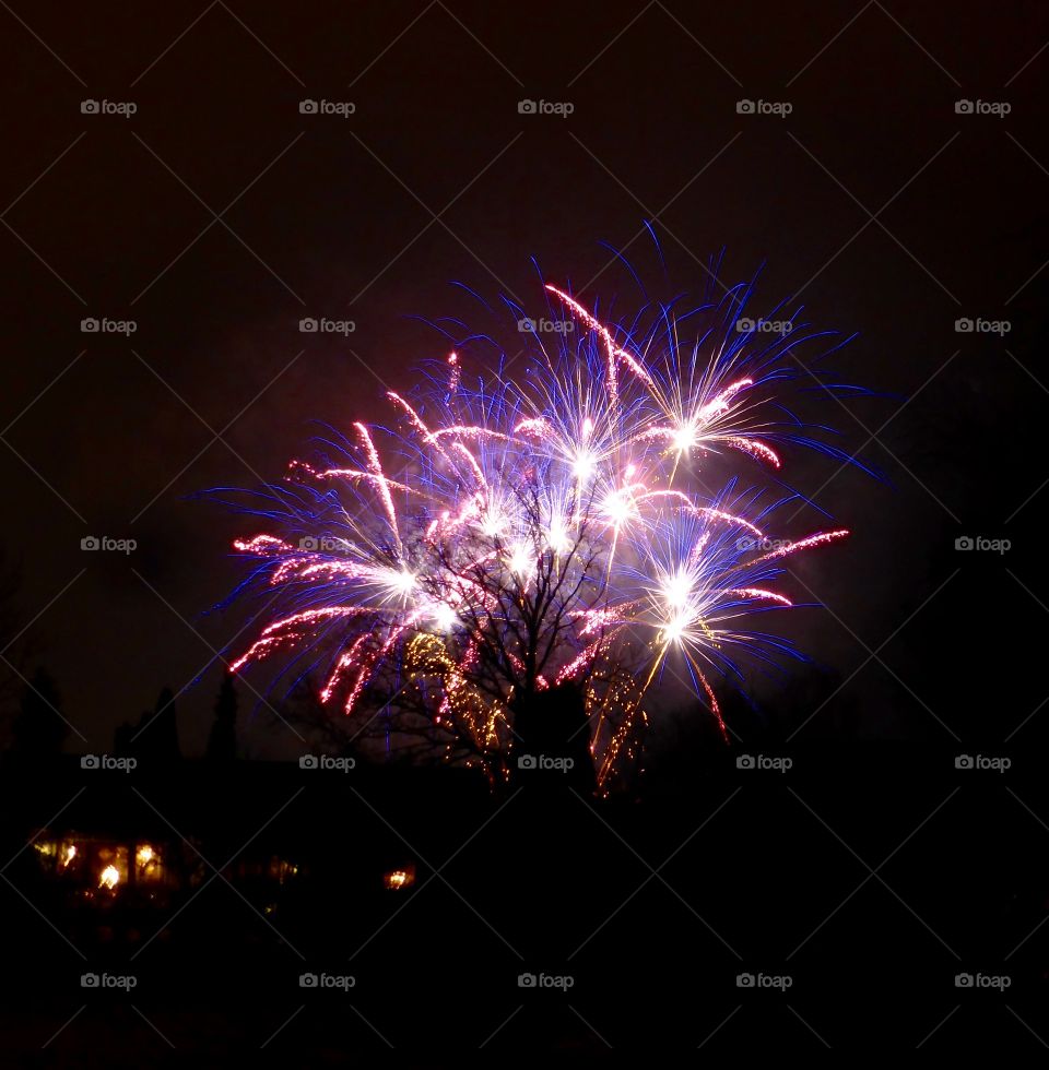 Illuminated firework display against clear sky at night