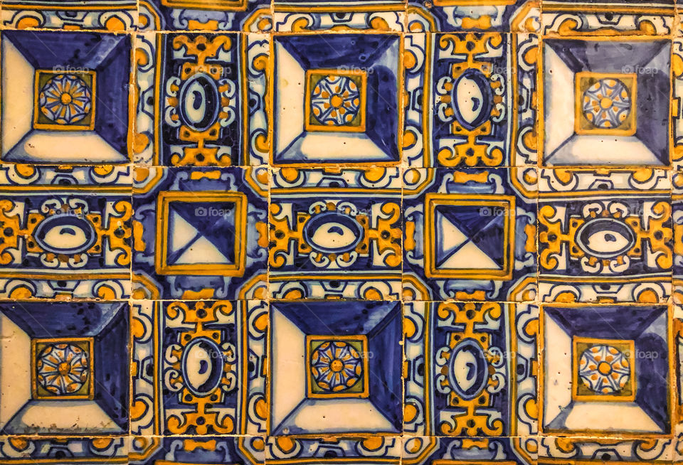 Hand painted blue, orange a white tiles found on the walls at the Convent of Christ, Tomar, Portugal