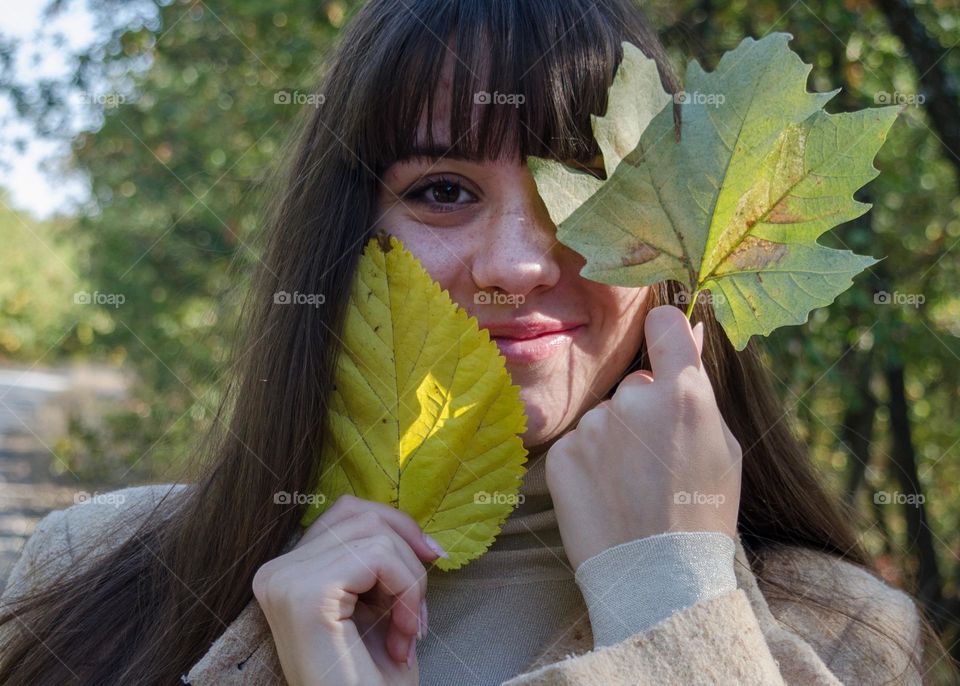 Portrait of Smiling Young Girl on Autumn Background