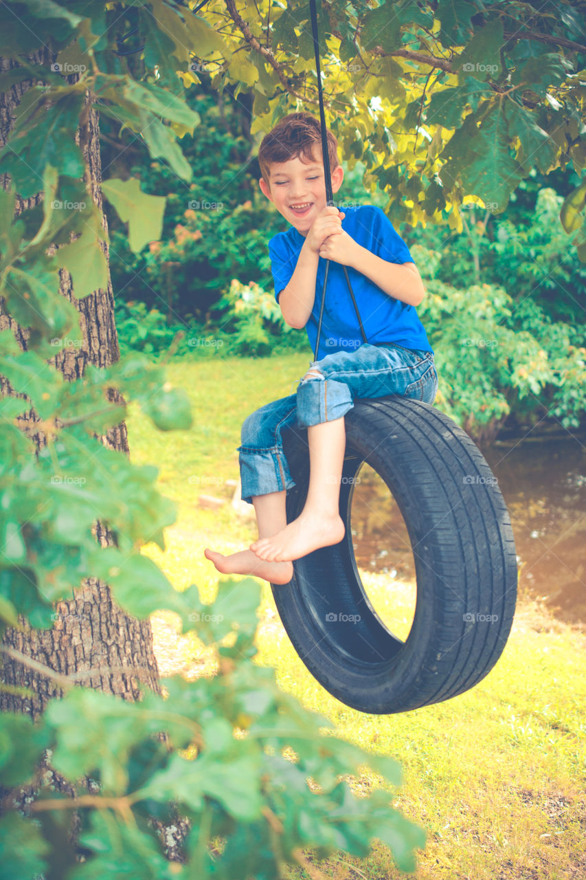 Young Boy Swinging on a Tire Swing