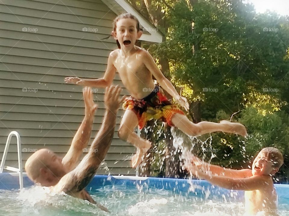 Balm man with children enjoying at garden swimming pool