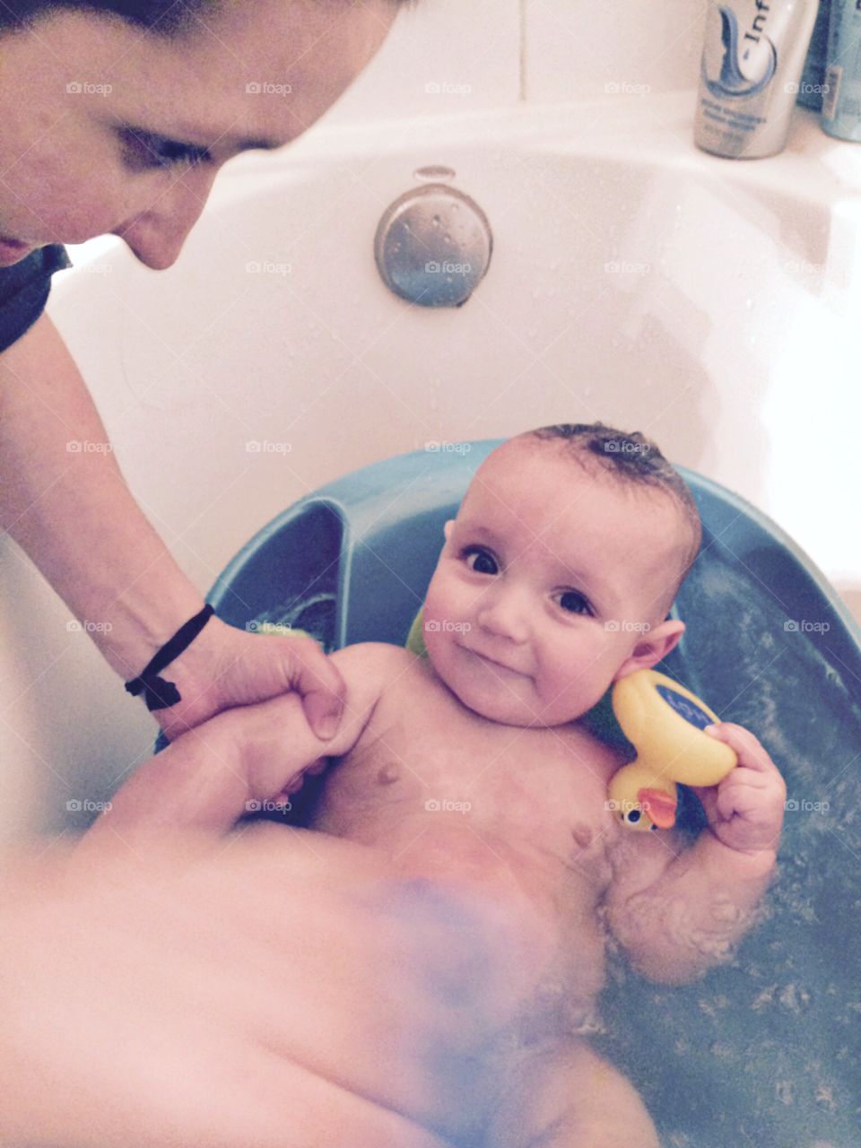 A happy baby getting a bath