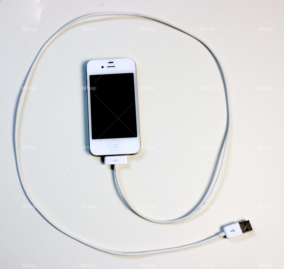 iPhone with cable attached like an @ sign