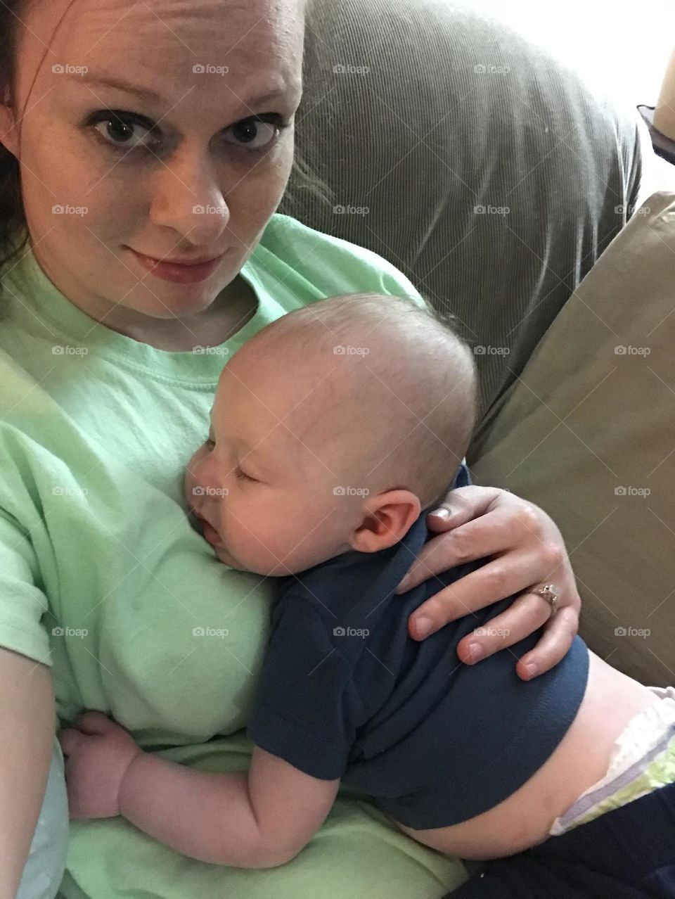 A baby is at peace as he naps on the chest of his mother 