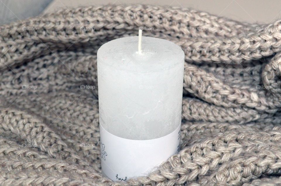 White candle on a knitted background