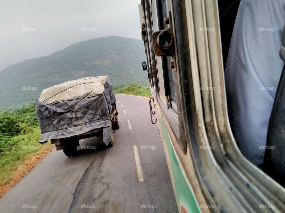 View of bus overtaking trunk on road