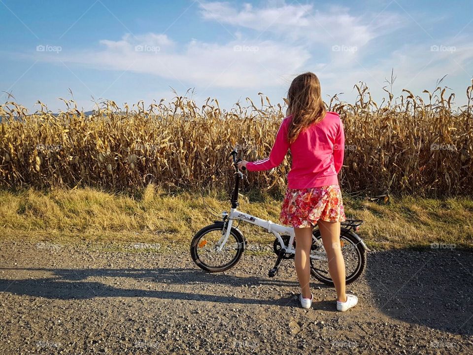 Woman and her bike near the corn field