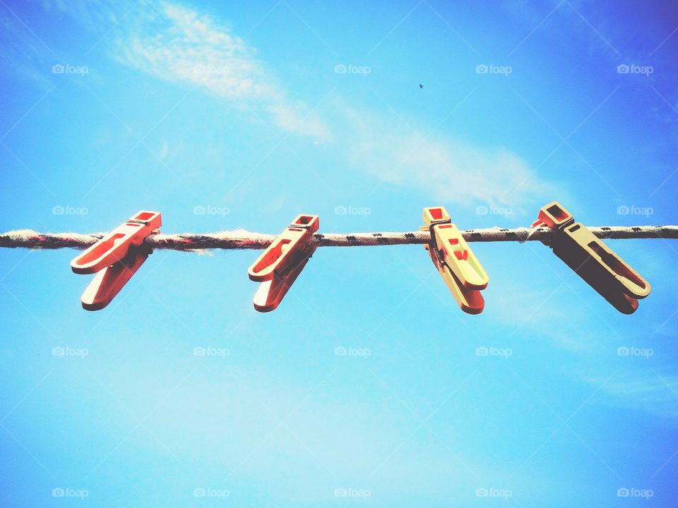 blue x orange by foaр missions,orange clothespins hanging on blue sky background