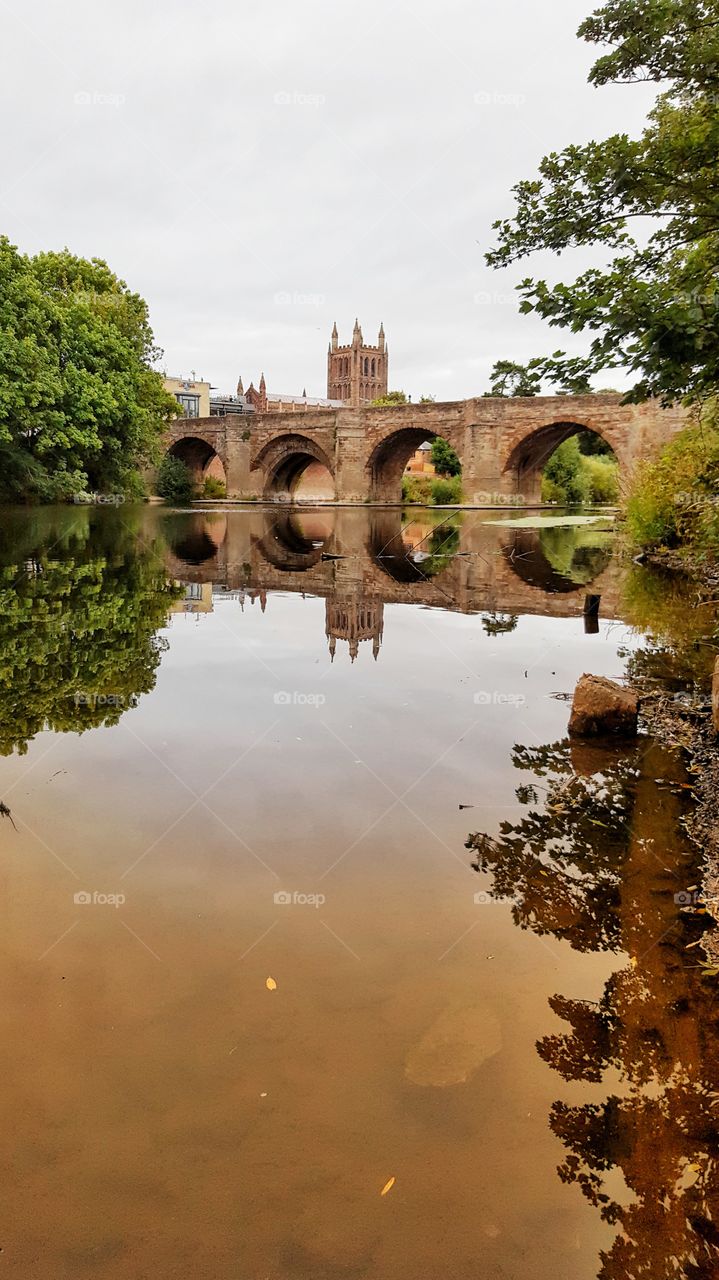 Gorgeous bridge reflection in the river with cathedral at the background