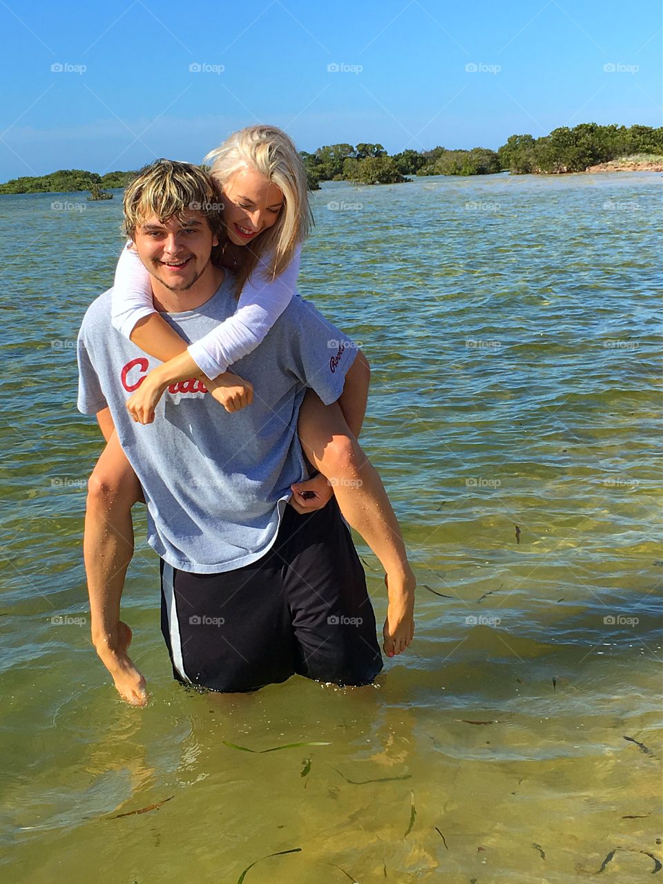 Young couple having fun in the water ocean