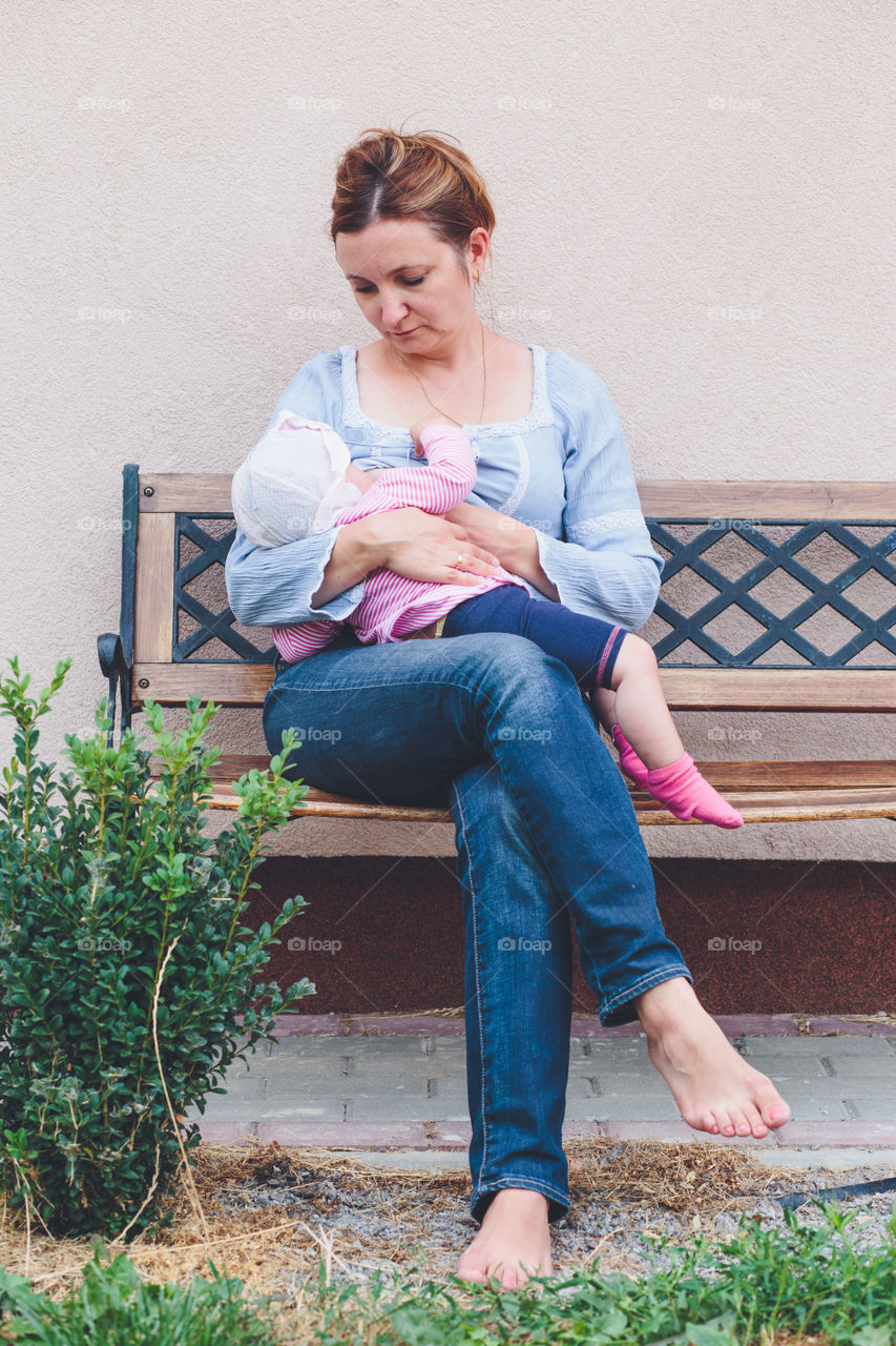 Mother sitting on bench nursing baby