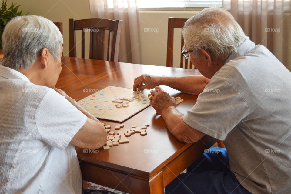 A couple playing Scrabble at home