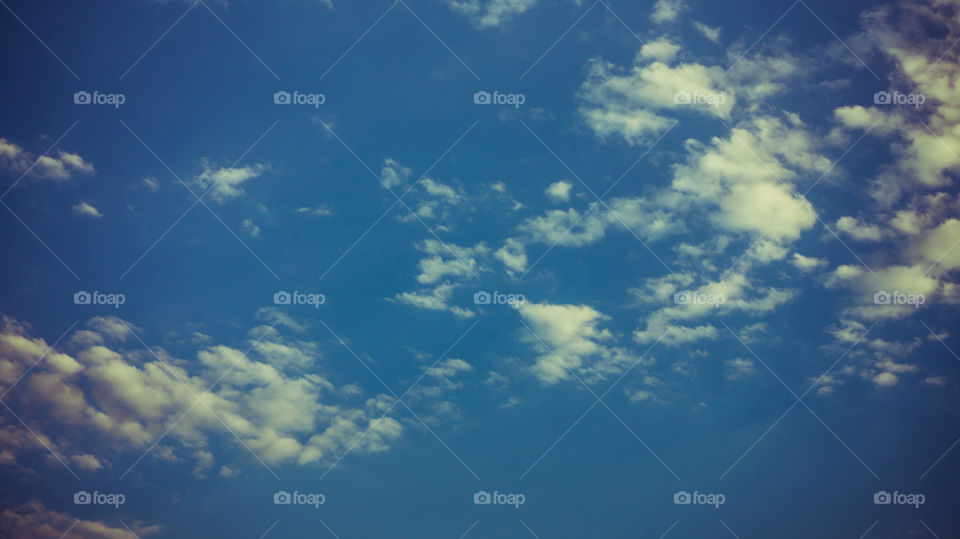 Large clouds float across the sunset sky like sails.